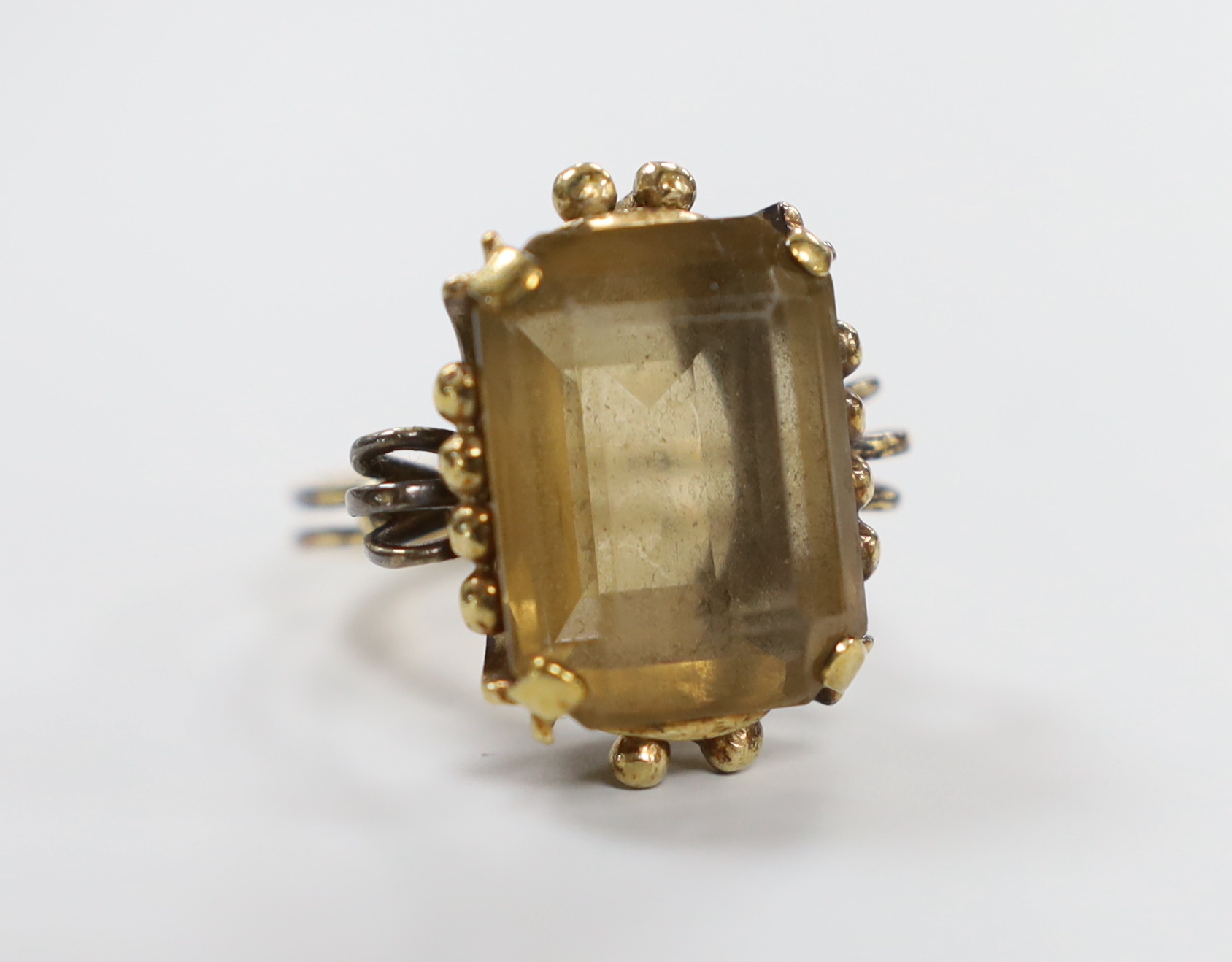 An early 20th century yellow metal and emerald cut citrine set dress ring, size R/S, gross weight 12 grams.